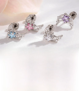 Detailed view of titanium steel star and moon stud earrings with colored zircon stones