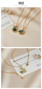 Detail of gold star and moon planet pendants on silk with cosmic blue textures