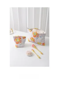 Detail of floral embroidered cosmetic bags with yellow tassels and gold metal zippers