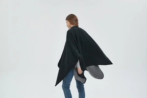 Close-up of black and grey color-block knit cape with split sides and hem stitch detail