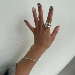 Close-up of minimalist S925 sterling silver chunky irregular ring and beaded bracelet