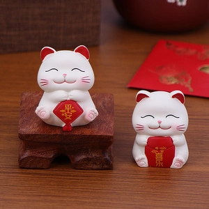 Set of two white lucky cat figurines with peace and joy inscriptions on wooden tray