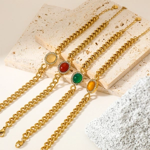 Set of four heavy metal link bracelets with colorful oval agate stones on a stone base