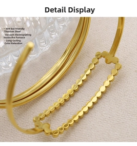 Detail of 18K gold plated titanium steel bangle with elegant dot texture and open design