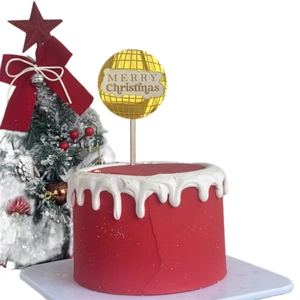 Merry Christmas acrylic cake topper with gold mirror finish on a festive red cake