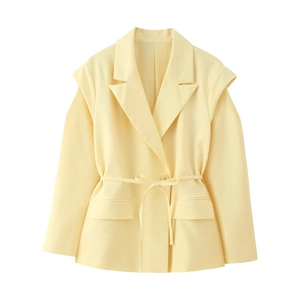 Détail d'un blazer jaune clair avec revers classique et ceinture à nouer assortie