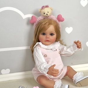 Lifelike 55cm reborn baby doll with blonde hair in pink knit overalls and white ruffle shirt