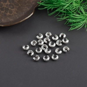 Macro shot of silver plated copper moon crimp beads with frosted texture for DIY jewelry