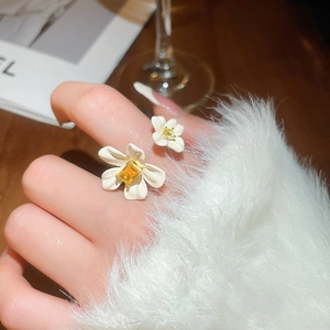 Macro detail of double flower open ring featuring white petals and yellow zircon centers