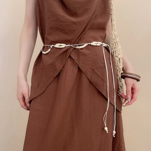 Detailed close-up of handmade acrylic and wood bead belt styled on a brown cotton dress