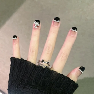 Detail of pink and black gradient press-on nails with 3D Saturn charm and rhinestones