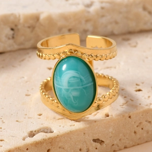 Detailed close-up of a double-band gold ring with turquoise oval stone and beaded accents