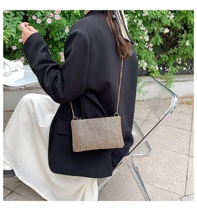 Detail of rhinestone chain bag on black suit jacket shown from a lifestyle perspective