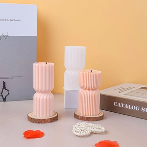 Vertical striped hourglass candles on wooden base with decorative books and petals