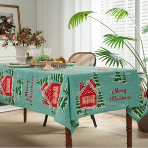 Teal Christmas tablecloth with red house and snow pattern on a festive wooden table