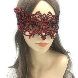 Detail view of red lace mask with gold stamping and intricate embroidery on mannequin