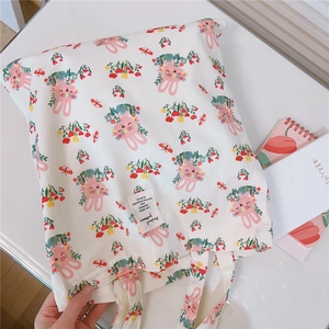 Detailed shot of cute bunny and floral print on white canvas tote bag with woven label