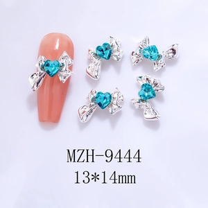 Detail of silver alloy bow nail charms with blue heart crystals, size 13x14mm
