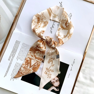 Detail view of giraffe pattern silk scarf showing material texture and laundry care label