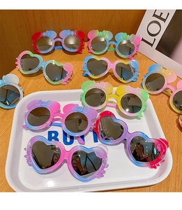Close-up of colorful heart and mouse shaped kids sunglasses with gradient frames