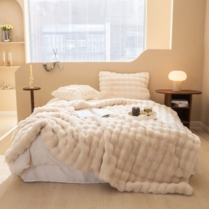 Close-up of cream white faux rabbit fur throw blanket with soft plush striped texture