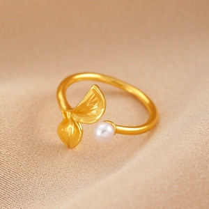 Detailed macro view of gold leaf ring with brushed texture and elegant white pearl