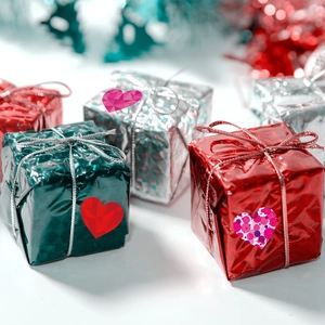 Close-up of metallic foil gift boxes with heart stickers for Valentine's day decoration