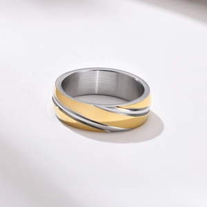 Detail of two-tone stainless steel ring with diagonal gold and silver textured stripes