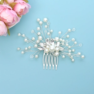 Exquisite bridal hair comb with white pearls and clear crystals on a blue backdrop