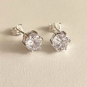 Macro detail of classic six-prong S925 sterling silver stud earrings with round zircons