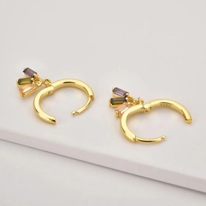 Detail of S925 sterling silver stamp on gold huggie hoop earrings with colorful zircon stones