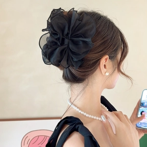 Grande pince à cheveux élégante avec fleur en résille noire portée vue de dos