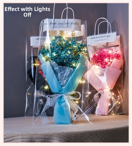 Close-up of dried gypsophila flower bouquet in PVC bag with LED lights and lace bow
