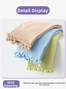 Detail view of wide elastic ruffled cuffs on cotton yoga socks in multiple colors