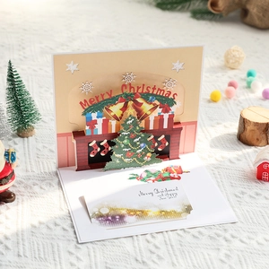 3D pop-up Christmas card featuring a cozy fireplace and festive tree scene