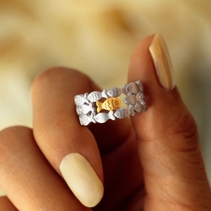Macro shot of silver fish-shaped ring with a gold accent fish detail for women