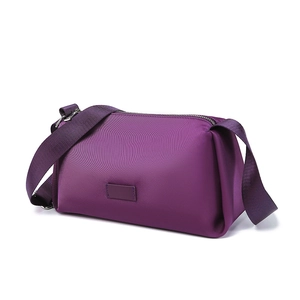 Bolso bandolera de nailon morado con correa ancha ajustable sobre fondo blanco