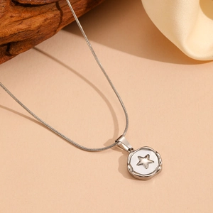 Detail of silver stainless steel snake chain with a round star embossed pendant