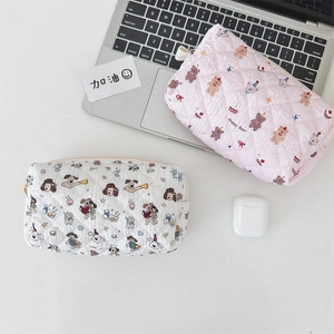 Detail of cute quilted pencil cases with cartoon bear and dog patterns on a white desk