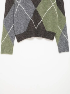 Close-up of argyle knit sweater hem and cuffs with grey, sage green, and brown patterns