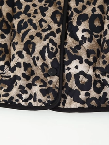 Detail of leopard print jacket showing diamond quilting and black button closure
