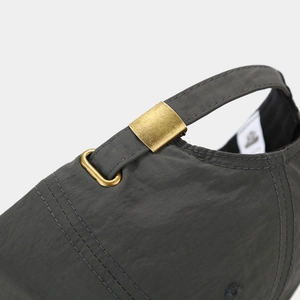 Detailed macro view of dark grey baseball cap featuring adjustable gold metal buckle
