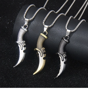 Close-up of hip-hop punk reaper scythe pendants in silver, bronze, and black metal finishes