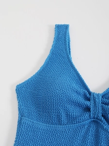 Gros plan sur la texture smockée bleu roi d'un maillot de bain une pièce à col en V