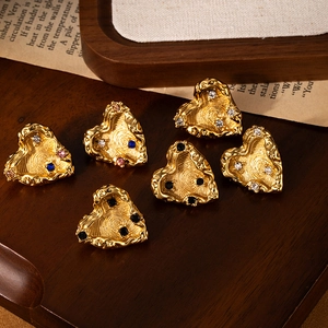 Elegant gold titanium steel heart earrings with colorful zircons on a wooden tray