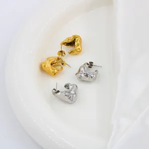 Detail von hohlen Lava-Ohrringen in Gold und Silber auf weißer Seide für Damen