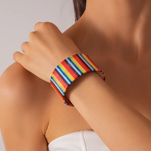 Detailed view of wide colorful striped acrylic cuff bracelet on a model wrist