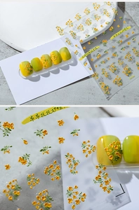 Macro detail of 3D embossed yellow osmanthus nail art stickers with green leaves