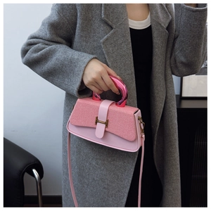 Close-up of pink textured fabric and leather crossbody bag with metal H-lock detail
