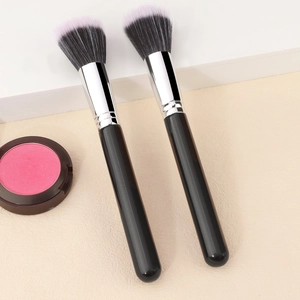 Macro detail of professional duo-fiber stippling powder brushes with black and pink bristles